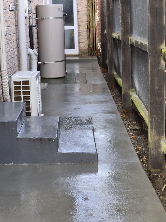 Reinstated concrete path beside a Christchurch house after earthquake drainage repairs