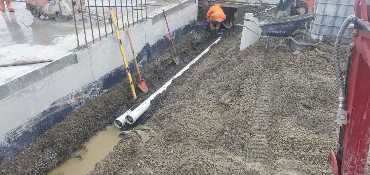 Drainage pipe laid along a commercial building foundation in Christchurch