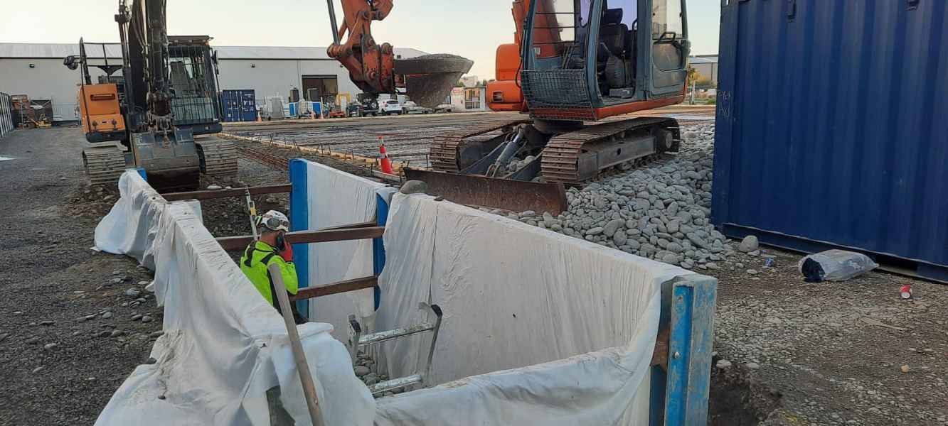 Shored trench and excavator on a commercial drainage job in Rolleston