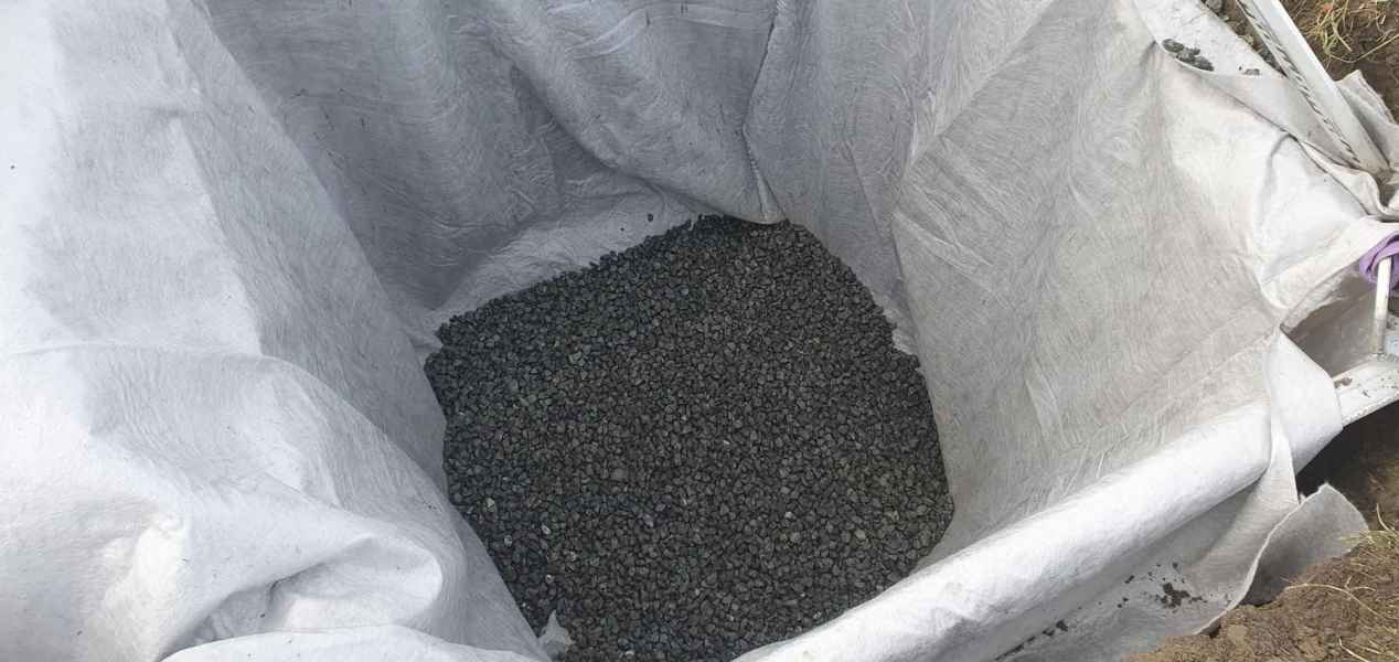 Excavation lined with filter cloth and filled with drainage aggregate on a Smart Contracting drainage job