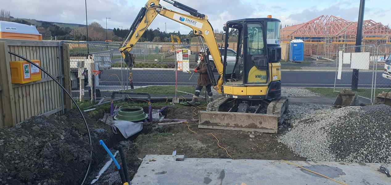Pressure sewer tank and collar set in an excavated pit in Christchurch