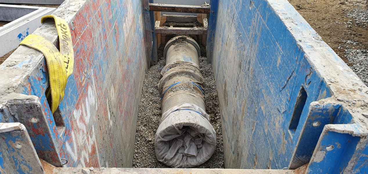 Large diameter concrete pipe set in a shored civil trench