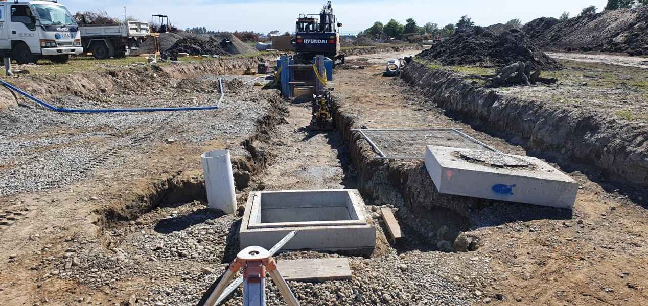 Long civil drainage trench with concrete chambers on a Canterbury project
