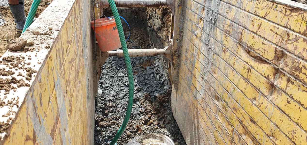 Shored civil trench with drainage pipe being connected in Canterbury