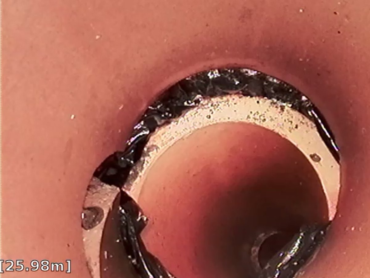 CCTV drain survey still showing root intrusion at a displaced joint in an earthenware pipe at 25.98 metres